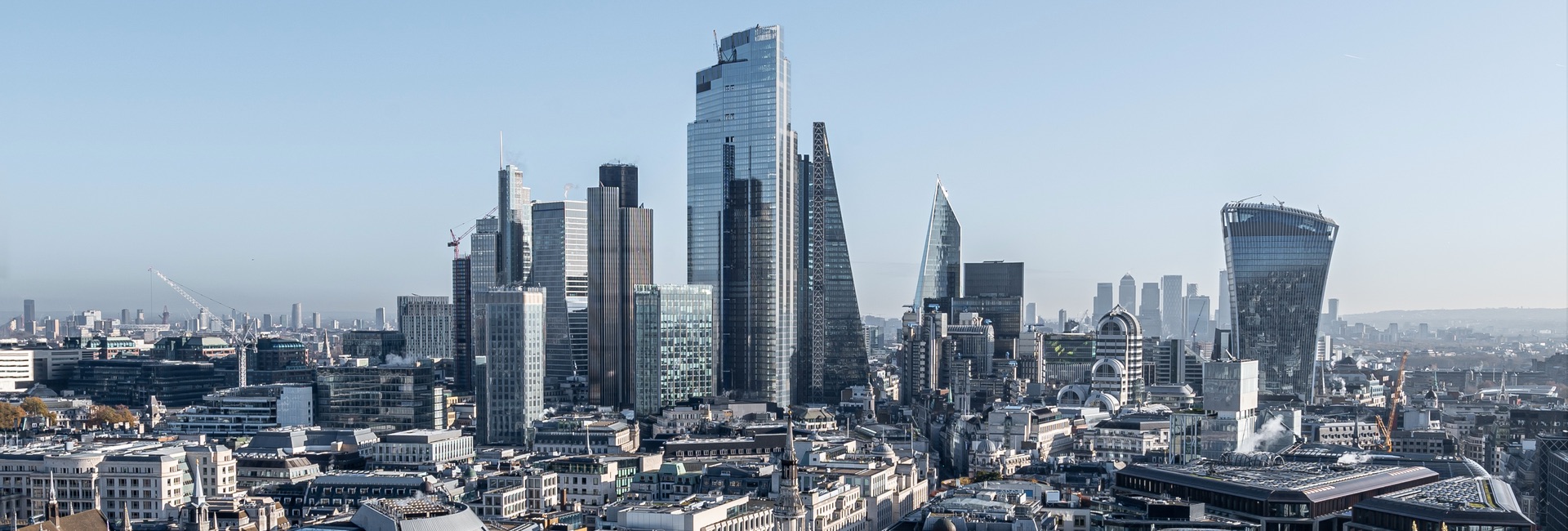 Distant view of sky scrapers against a blue sky forming the central London skyline.