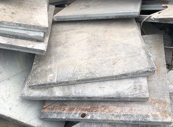 Pile of used raised access metal floor tiles.