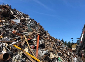 Large stockpile of scrap metal against a blue sky.