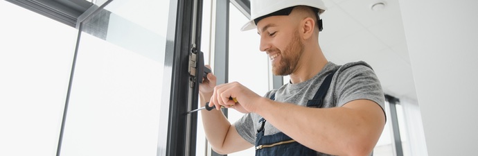 Contractor using a screw driver to remove a uPVC window for recycling