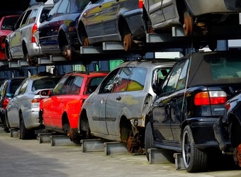 Scrap cars stacked on top of each other in a scrap yard.