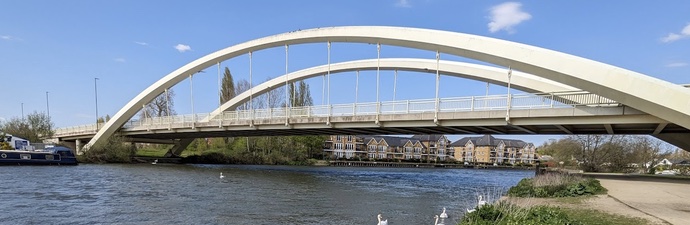 View from the riverbank of Walton On Thames bridge spanning the river thames.