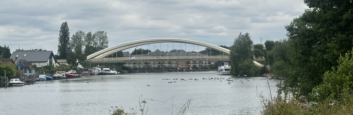 View from the riverbank of Walton On Thames bridge spanning the river thames.