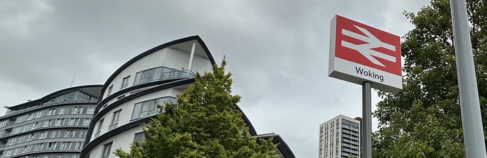 A crowd of pedestrians climbing steps that lead to the woking town centre shops.